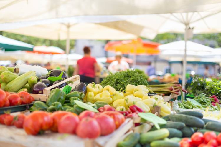 A farmers' market stand with many vegetables on display.