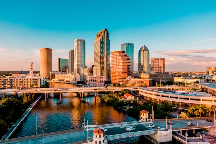 An aerial view of Tampa Bay, showing bridge over water with tall buildings.